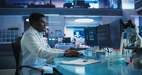 Aufkleber - Black Male Neuroscientist Using Desktop Computer To Analyze MRI Scans Of Brain In Medical Research Center Laboratory. African American Surgeon Studying CT Scan Of Patient Suffering From Brain Tumor.