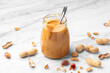 Peanut butter in glass jar on white marble table