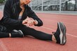 © Rawpixel.com - Woman warming up setting her smartwatch for tracking by stretching on a running track