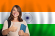 © artmim - Happy woman student against Indian flag background. Travel, education and learn language in India concept