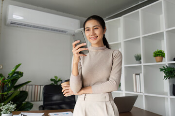 Wall Mural - Business woman having phone conversation with client in office. young woman using smart phone. Woman Hands Using Mobile Phone in the Office