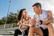 © Rawpixel.com - Athletic man and woman sitting down and talking by the stadium