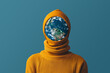 Portrait of planet earth in orange knit garment with hat. Concept of preserving planet earth from overproduction of clothing.