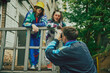 Making memories. Friends meeting outdoors, wearing retro style sport suits and accessories, having fun, recording video with vintage camera. Concept of 90s, fashion, youth culture, old-style trends