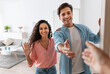 © Prostock-studio - Happy young couple inviting people to enter home, shaking hands