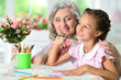 Portrait of a cute little girl drawing with her grandmother