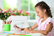 Portrait of cute little girl drawing picture at home