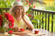 Happy aged woman drinking coffee and talking on phone