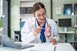 © NanSan - Caucasian woman sits at a desk, kidney model, gallstones, glomerulonephritis, acute and chronic kidney disease, infectious diseases, abnormal ureters, cysts, and urinary system cancer.