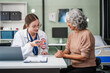 © NanSan - Caucasian woman and elderly Asian woman discuss kidney model issues like gallstones, glomerulonephritis, acute/chronic kidney disease, infections, abnormal ureters, cysts, urinary system cancer.