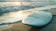 Surfboard on sandy beach at sunrise