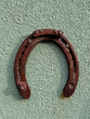 Vintage metal horseshoe for luck.Old rusty horseshoe on green wall background.