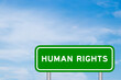 Green color transportation sign with word human rights on blue sky with white cloud background