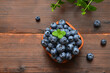 blueberries in a bowl on a wooden table close-up, copy space