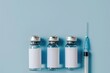 Syringe and glass vial on blue background flat lay. Medical Vials group, needles, ampoules, bottle with medicine, vaccine. Disease treatment. Creative Banner. Anti-aging beauty injections. Vaccination