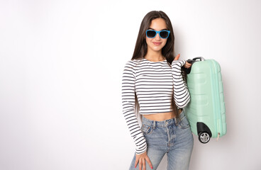 Excited young woman tourist with beautiful smile and suitcase, isolated on white background