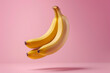 Levitating banana on pink background