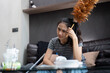 Tired young woman asian in the living room with cleaning products and equipment, housekeeper or overwhelmed girl with housework, stress cleaning, Housework concept