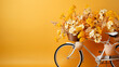 A bicycle with a basket full of flowers on yellow background with copy space.
