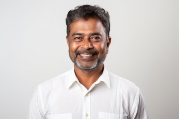 Poster - Portrait of a grinning indian man in his 40s wearing a classic white shirt over white background