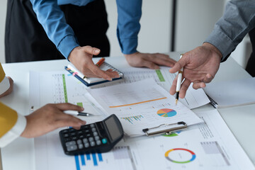 close-up hands image, Professional Asian male and female financial consultant or analyst working with them team, brainstorming and analyzing financial data on the report together in the office