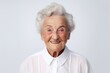 © CogniLens - Portrait of a jovial elderly 100 year old woman wearing a classic white shirt over white background