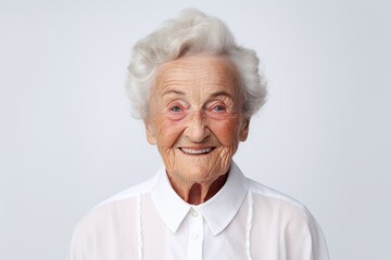Wall Mural - Portrait of a jovial elderly 100 year old woman wearing a classic white shirt over white background