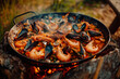 Traditional spanish seafood paella cooked on the fire outdoors