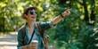 © LukaszDesign - Woman with rucksack or pointing in nature travel, park or birdwatching in Canada or trees. Hiking with coffee, smiling tourist with hand signal
