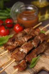 Wall Mural - Tasty cooked marinated meat served with sauce and tomatoes on table, closeup