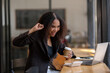© Wasana - Joyful African American businesswoman celebrating a successful moment while using her laptop in a bustling café.