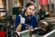 Portrait engineer worker thumbs up professional working in metal lathe milling machine heavy industry factory.