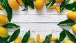 Vibrant display of fresh mangoes with lush green leaves on a white wooden background.