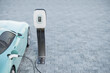 3d render of a nondescript Electric vehicle plugged into a Charging station on a parking lot with paving stones. Plenty of copy space - selective focus on the display of the charging station.