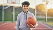 © Marko - A teen boy in athletic wear confidently holding a basketball on an outdoor court
