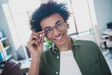 Wall Mural - Photo of cool smart employee wear khaki shirt arm hand eyeglasses smiling indoors workstation workplace