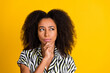 Portrait of touching chin clever woman in shirt with beautiful curly hair pensive planning her day isolated on yellow color background