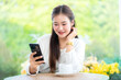 Portrait of beautiful happy Smiling asian woman writing message using smartphone relaxing sitting in cafe interior in coffee shop background,Business Lifestyle summer holiday concept