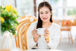 Portrait of beautiful happy Smiling Holding a glass of Hot coffee latte asian woman relaxing sitting in cafe interior in coffee shop background,Business Lifestyle summer holiday concept