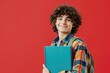 © Nognapas - Portrait of smiling smart curly haired teenage boy holding book looking at camera. Back to school, Education concept