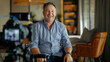 © OMGAi - Smiling Man Being Interviewed on Camera. Cheerful man in a casual shirt sitting for an on-camera interview in a cozy room, giving a sense of approachability and openness.