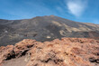 un rocher rouge avec le sommet d'un volcan en arrière plan