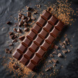 Large milk chocolate bar with broken pieces and cocoa powder on a dark background, flat lay