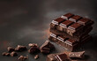 Stacked dark chocolate bars with scattered pieces on dark background with copy space