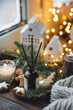 Christmas home aromatherapy. Aroma diffuser with pine extract, organic essential oil, cedar and spruce cone, cinnamon, anise, vanilla scent, candles, wooden table. Cozy atmosphere, winter inspiration
