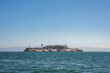 Alcatraz Island, San Francisco Bay, California, USA. Former federal prison, rocky, barren island with aged buildings. Water tower, lighthouse, blue waters, hills, sunny sky, isolation theme.