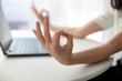 Close up image of woman's hands who was sitting and meditating at his desk in a white office To meditate to calm the mind and relax before starting work. The room is bright with natural light.
