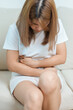 woman having abdomen ache due to Stomach pain, digestion with constipation or Diarrhea from food poisoning, female problem and Endometriosis, Hysterectomy, Stomachache and Menstrual on sofa at home