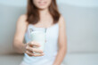 Milk drink and Daily Routine concept. Young woman Drinking milk with high calcium and nutrition at home, woman holding soy milk on glass with protein. Healthy, wellness and happy lifestyle