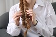 © New Africa - Woman with braided hair on sofa indoors, closeup